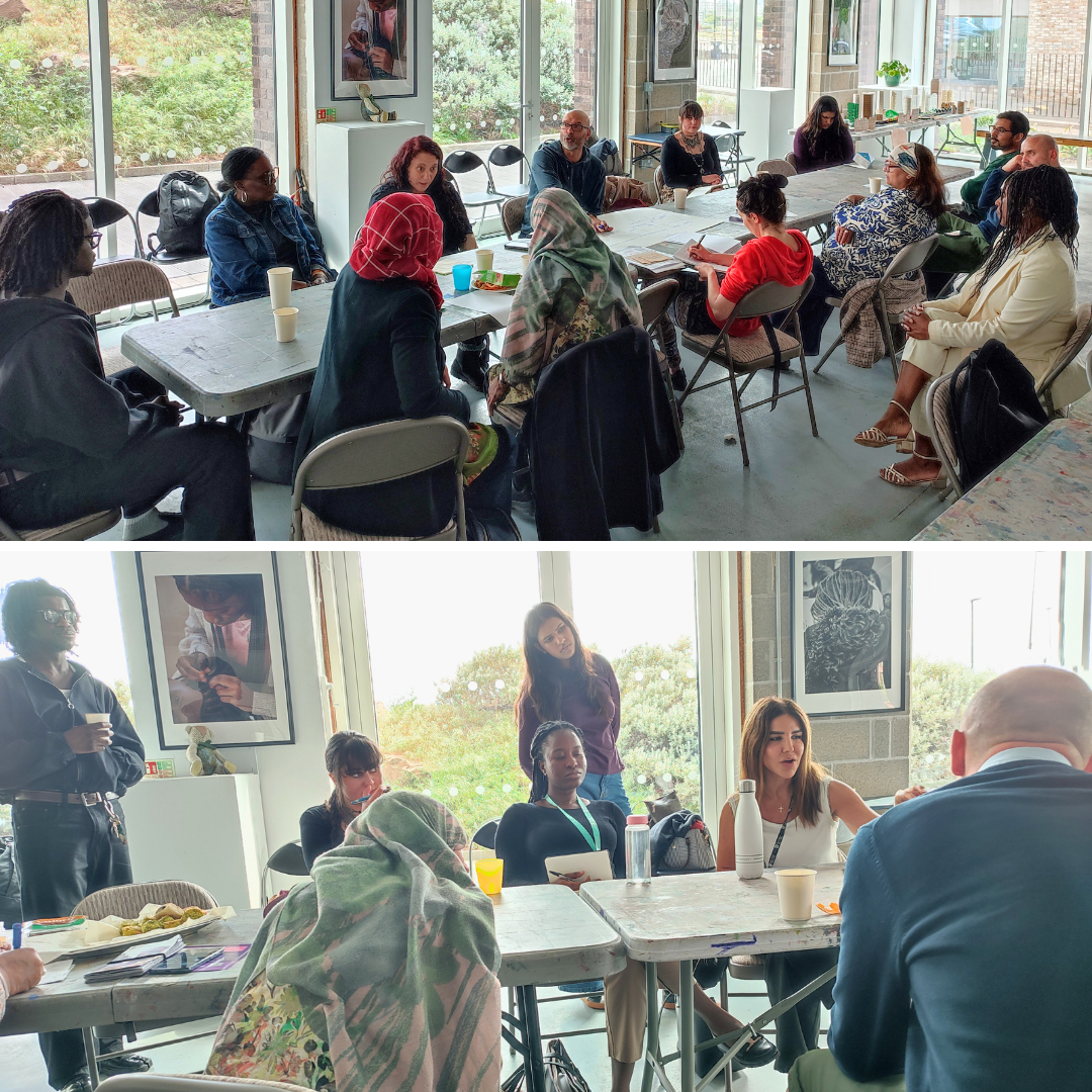 A diverse group of people sit at long tables talking at the networking event
